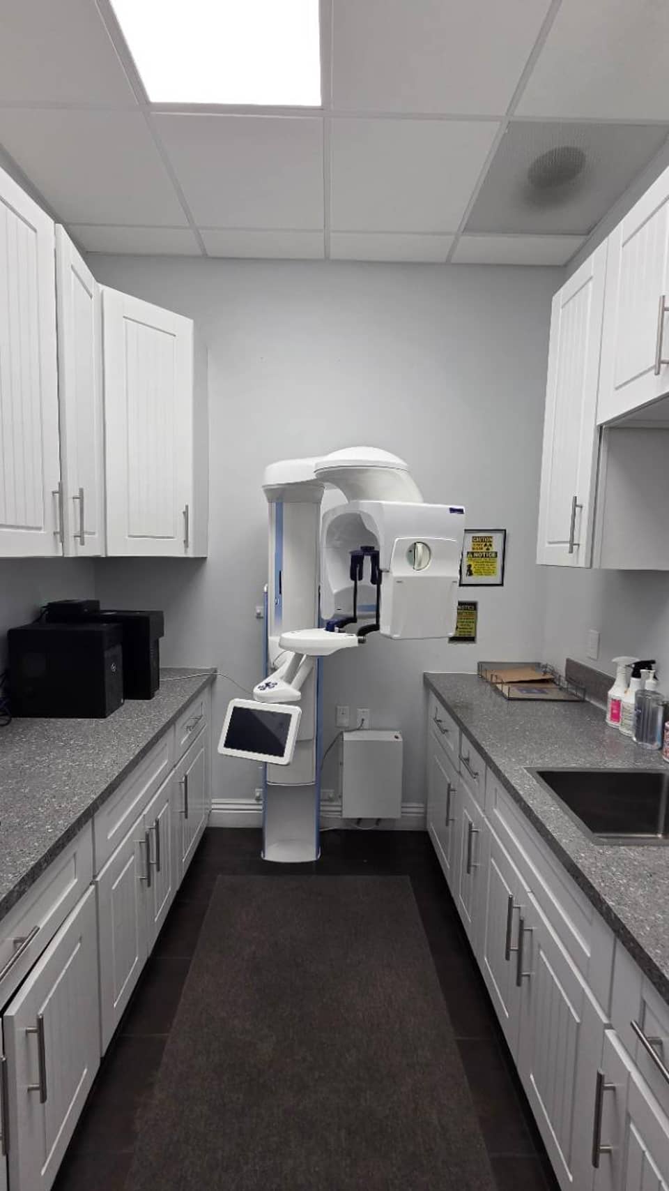 Imaging room at Ayat Dental with equipment between white cabinets