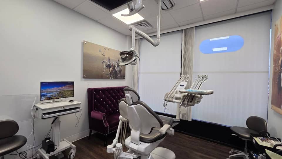 Dental chair, examination light and burgundy seating at Ayat Dental